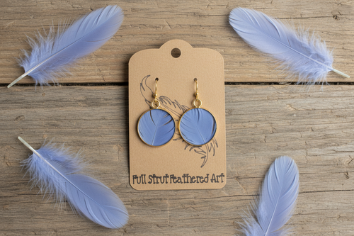 Rustic flat lay of Blue Skies goose feather earrings on weathered barn wood