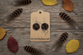 Rustic flat lay of Dark Timber turkey feather open bezel earrings on weathered barn wood