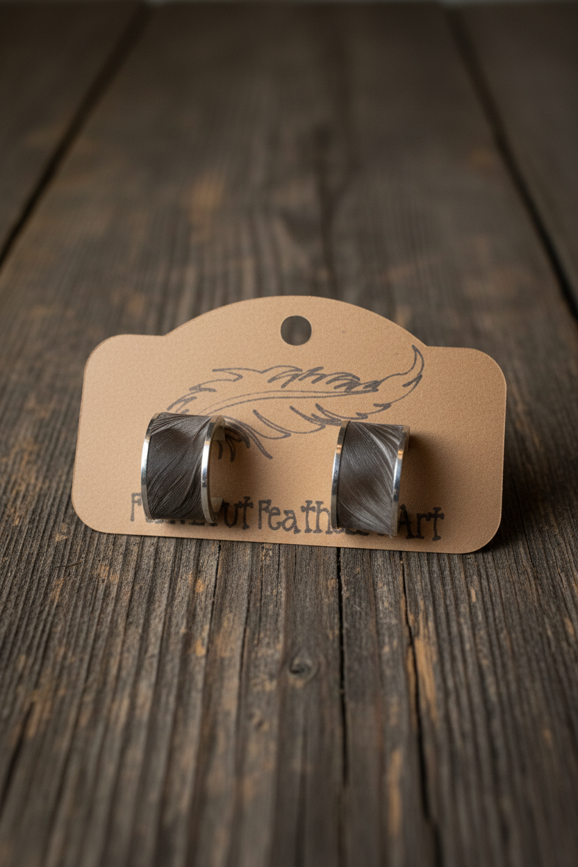 Dark feather wide cuff bangle earrings with silver trim on rustic wood background