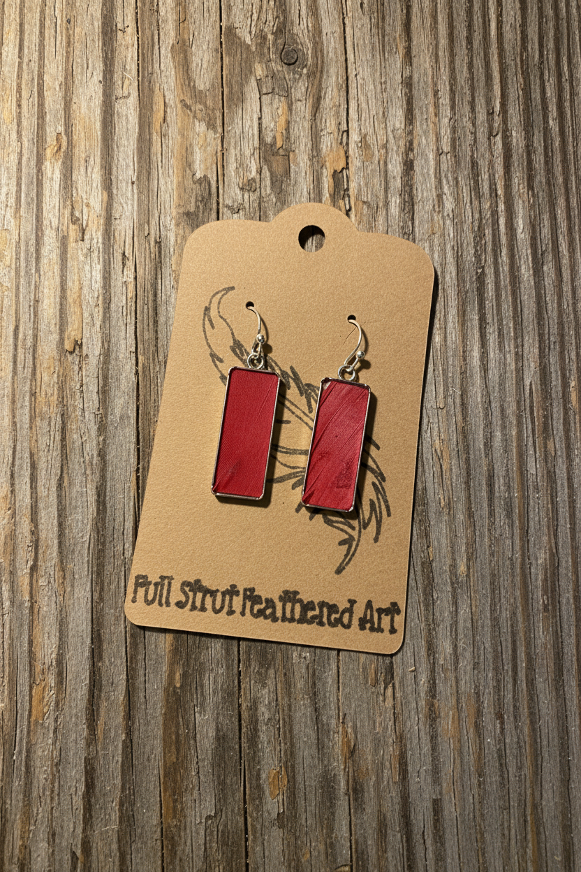 Red feather rectangle earrings with silver bezel on rustic wood background